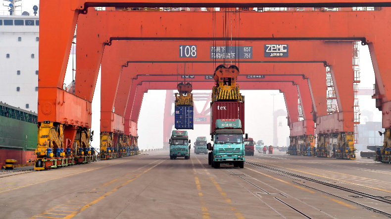 Trucks being loaded with containers at port