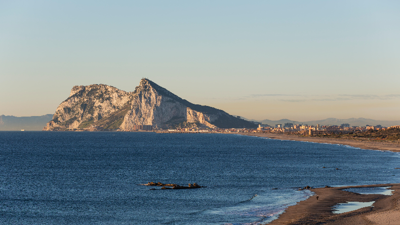 The rock of Gibraltar seen across the sea and a beach