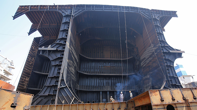 Workers dismantle a decommissioned tanker at the Alang shipyard