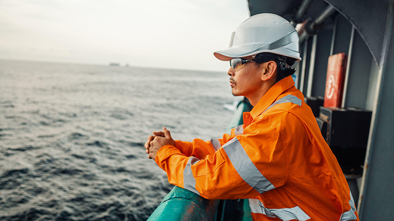 Deck officer on ship gazing out to sea