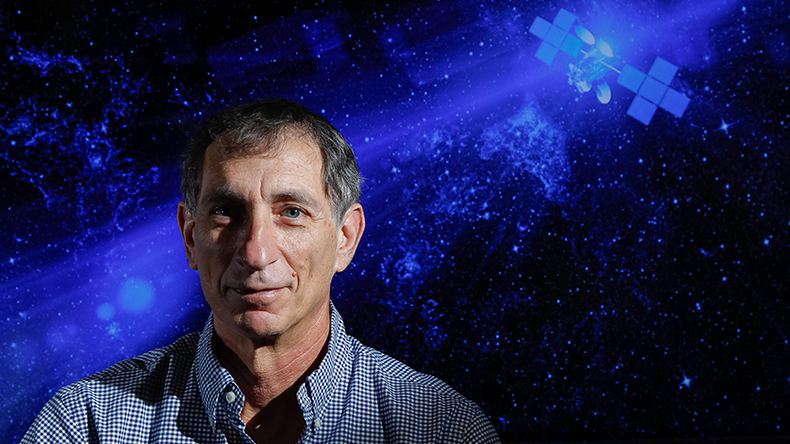 Viasat CEO Mark Dankberg pictured against a background of satellites in space