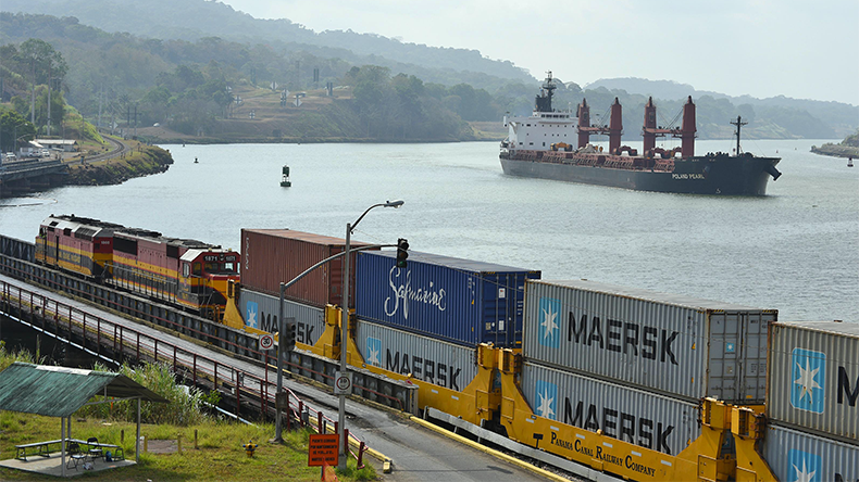 Panama Canal with dry bulker and freight train
